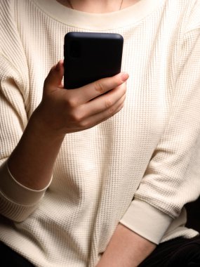 Akıllı cep telefonu kullanan bir kadının yakın çekimi. Kadın ellerinde akıllı telefon.