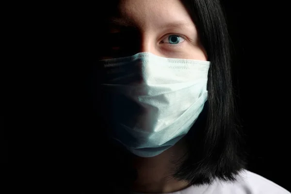 A young girl in a medical mask sneezes, covering her mouth with her hands. The concept of the seasonal infections, Flu, Rhinitis, cold, sickness, allergy, Coronavirus