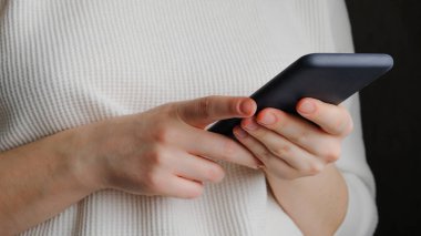 Kızın elinde bir akıllı telefon var. Elindeki ekrandaki akıllı telefona dokun. İş kadını sosyal ağlar ve modern teknoloji kavramı. sanal iletişim