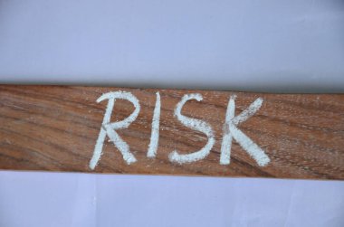 word risk written on wooden block with red letters.