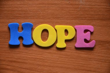 Tahta küplerin arka planında umut kelimesi