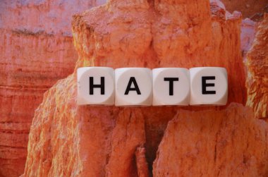 Mektubun küplerinden gelen nefret kelimesi güzel ahşap bir masa üzerinde güzel turuncu bir arka plan, bir ilişki konsepti, barış.