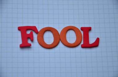 Yüzün yüzeyindeki kelimenin 3 boyutlu bir çizimi ve kafasında bir harf var..