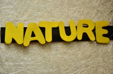 Tahtadan yapılmış doğal bir kelime, sarı ahşap bir masada.