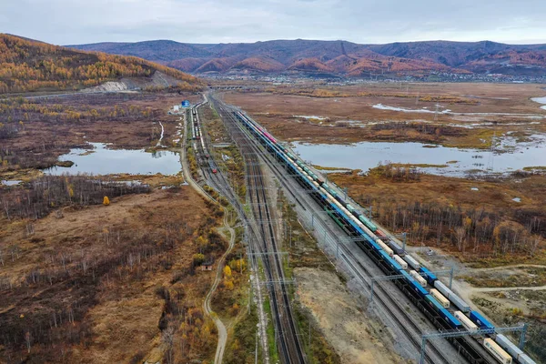 Demiryolu taşımacılığı. Trans-Sibirya demiryolunun bir bölümü, Baykal Gölü 'ndeki Slyudyanka istasyonu. İstasyondaki yük trenleri. Hava görünümü.