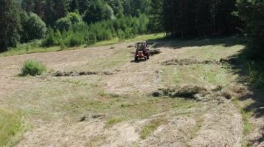 Güney Uralları. Dağ çayırı. Traktör samanlıkta. Hava görünümü.