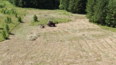 Güney Uralları. Dağ çayırı. Traktör samanlıkta. Hava görünümü.