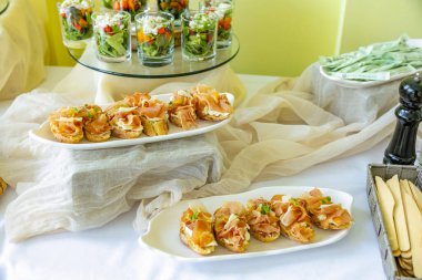Prosciutto soslu crostini ve keten kaplı açık büfe masasında düzenlenen salata fincanları etkinlikler için ordövrler..