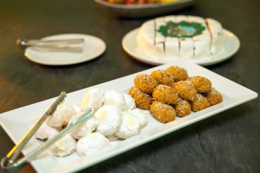 Tatlı Yuvarlak Toplar ve Servis Tabağında Zarif Tozlu Kurabiyeler içeren Geleneksel Tatlıların Lezzetli Gösterimi