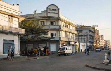 Nişanlısı, Madagaskar - 06 Mayıs 2019: Tipik sabah sahnesi - şehir caddesi, okula yürüyen üniformalı genç kızlar, uzaktan gelen arabalar, çoğunlukla otellerde güneş ışığı alan binalar.