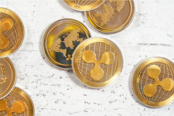 Üst aşağı görünüm - altın XRP - dalgalı kripto para - beyaz taş tahtada sikkeler