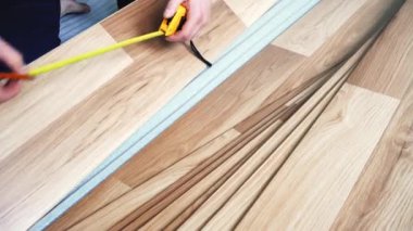 Kaplamalı döşeme döşemesi kuran adam - ellerinde uzunluğu kalem ve bant ile ölçen detay
