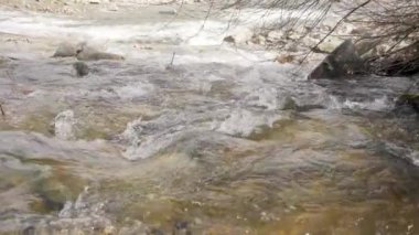 Güneş, bahar nehrinde akan suyun üzerinde parlıyor, yavaş çekim videosu