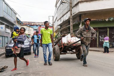 Antananarivo, Madagaskar - 24 Nisan 2019: Bilinmeyen Malagasy 'li adam beyaz çantalı, elinde çocuğu olan kadın, daha fazla yerli. 
