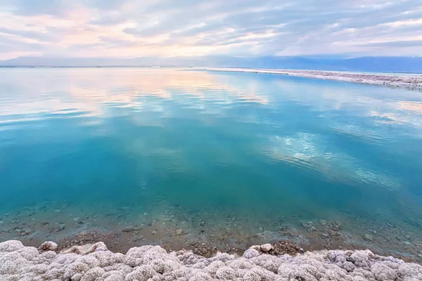 Salt crystals covering sand shore of Dead Sea, calm clear water surface near, typical morning scenery at Ein Bokek beach, Israel — Stock Photo, Image