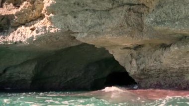 Denizde yüzmek, kayalık kıyılarda ve küçük mağaralarda dalgalar, suyun altında yüzmek, sonunda görünen balıklar.