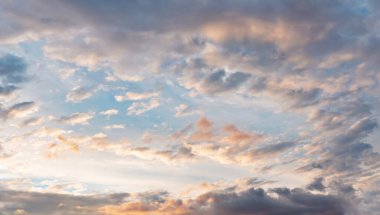 Akşam gökyüzü biraz sarı turuncu, pembe, beyaz, gri ve koyu bulutlu