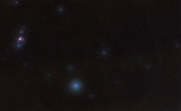 Winter nachtelijke hemel met paarse Orion nevel, heldere blauwe Rigel ster - verspreid door sommige wolken - in het onderste deel, lange belichting foto — Stockfoto