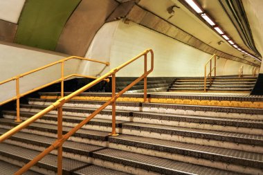 Merdivenler ve sarı raylar yeraltı tren tüneline çıkıyor.