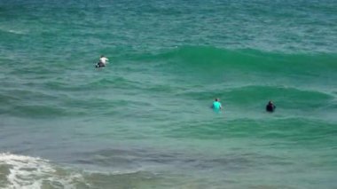 Cales de Mallorca, İspanya - 21 Eylül 2019: Bilinmeyen sörfçüler sörf tahtalarının üzerinde suda yatıyor, akşam deniz kıyısında dalgaları bekliyorlar