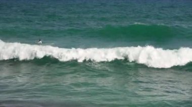 Cales de Mallorca, İspanya - 21 Eylül 2019: Bilinmeyen sörfçüler sörf tahtalarının üzerinde suda yatıyor, akşam deniz kıyısında dalgaları bekliyorlar