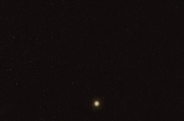 许多夜空中的恒星在较低的地方有明亮的弧形突起 阿尔法布偶星座 它是第四亮的恒星 长期堆叠的曝光照片 — 图库照片