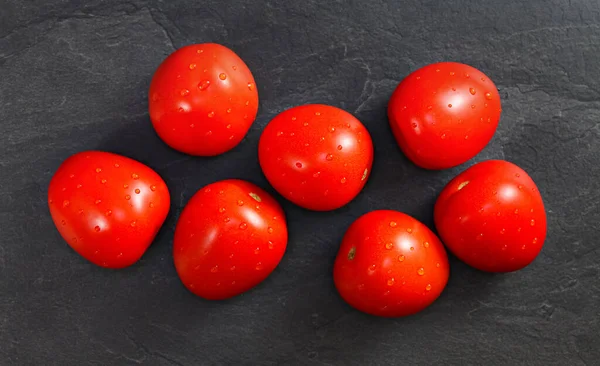 俯瞰全景 七只小西红柿 水滴在黑色石桌上 — 图库照片