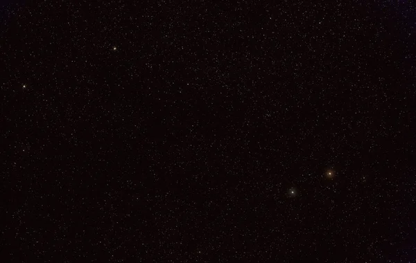 Many stars on night sky with bright Yed Prior and Posterior stars, Messier 10 and 12 deep space objects visible in upper left corner (long stacked exposure photo)