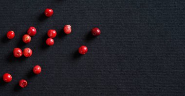 Siyah / gri kağıt üzerinde tam pembe / kırmızı biber, yukarıdan görünüm, metin sağ tarafı için boşluk