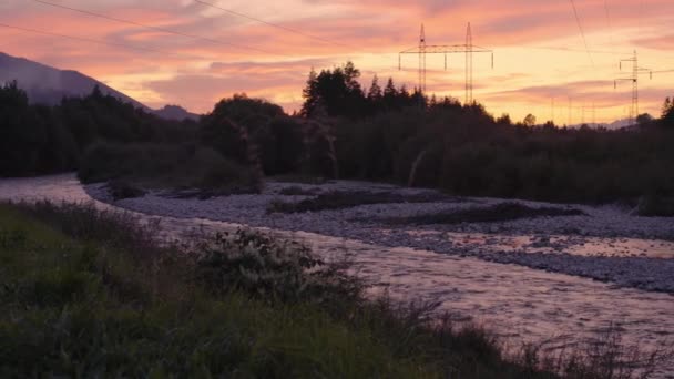 河流附近森林上空的夕阳西下的云彩 远处电塔和电缆的轮廓 — 图库视频影像