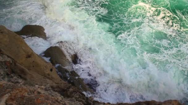 바위가 해안에 부딪치는 파도들 위에서 느리게 움직이는 영상을 수있다 — 비디오