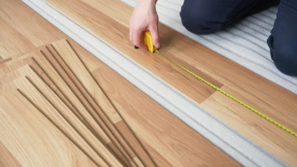 Man Installing Laminated Flooring Detail His Hands Measuring Length Pencil — Stock Video