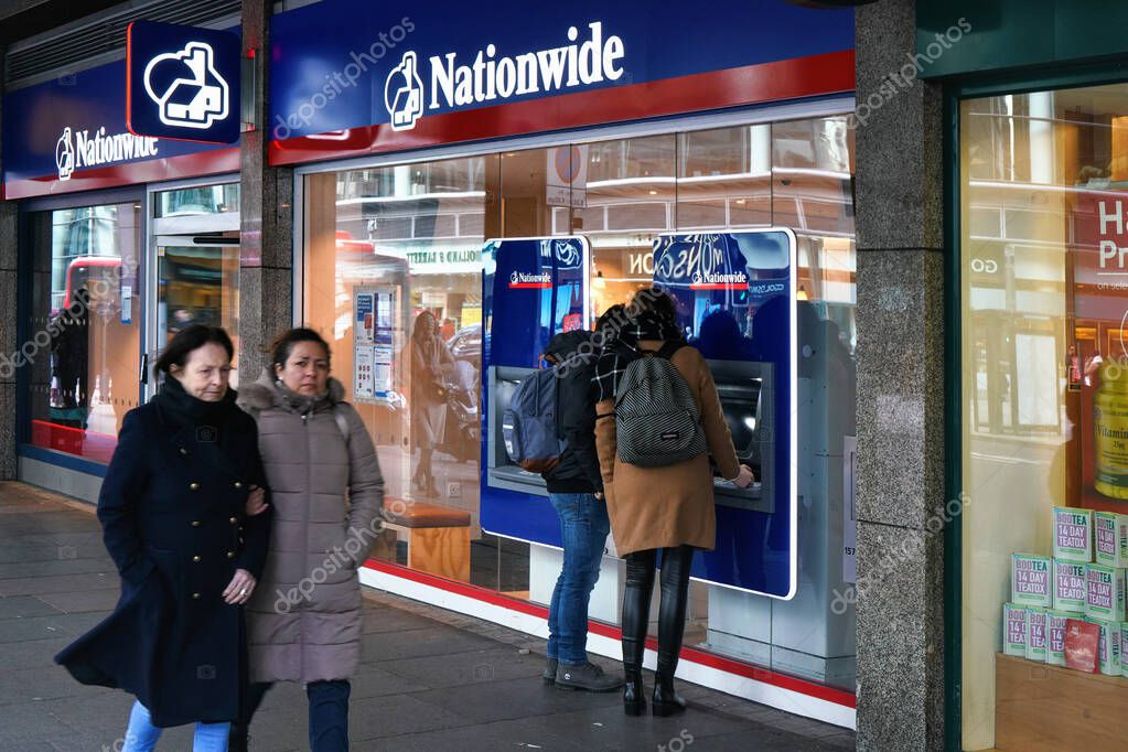 London, United Kingdom - February 02, 2019: People walking in front of Nationwide ATM machines near their branch at Victoria. British mutual financial institution founded in 1846