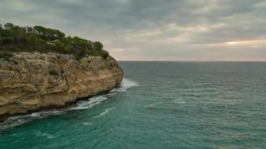 Sabah bulutları sakin denizin üzerinde, kayalık kıyılar solda, zaman kavramlı video