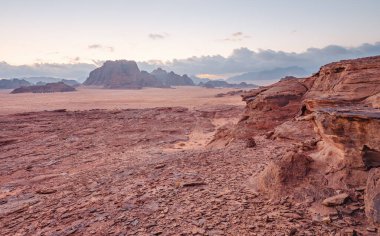 Kırmızı turuncu Mars, Ürdün Wadi Rum Çölü 'ndeki manzara gibi. Dağların arka planı, bulutlu bir sabah. Bu konum birçok bilim kurgu filminde kullanılmıştır.