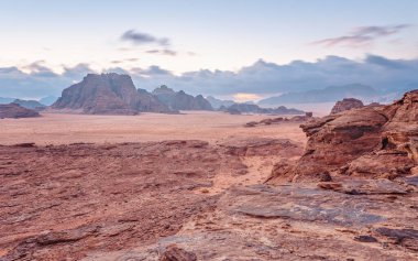 Kırmızı turuncu Mars, Ürdün Wadi Rum Çölü 'ndeki manzara gibi. Dağların arka planı, bulutlu bir sabah. Bu konum birçok bilim kurgu filminde kullanılmıştır.