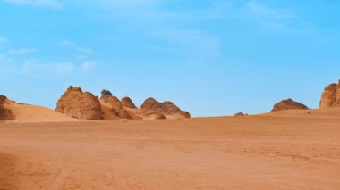 Al Ula, Suudi Arabistan 'daki tipik çöl manzarası. Uzakta bazı dağları olan yerel halk.