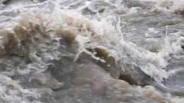 Hızlı kirli nehir dalgaları, havada uçan su damlaları, yavaş çekim detaylarını kapatın.