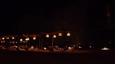 Alula, Suudi Arabistan - 4 Mart 2023: Yerliler ve turistler Jabal AlFil yakınlarında kahve içiyorlar - Fil Kayası, manzara aydınlanıyor, insanlar için yere kurulmuş koltuklar