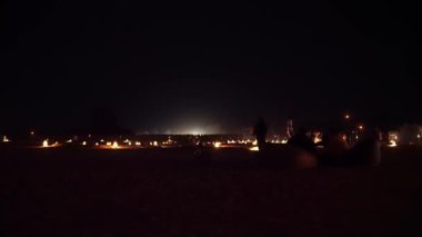 Alula, Suudi Arabistan - 04 Mart 2023: Jabal AlFil yakınlarında yürüyen yerli ve turistler - Akşam saatlerinde Fil Kayası 'nın yanında yürüyen turistler, manzara aydınlanıyor, yerde insanlar için koltuklar kuruluyor