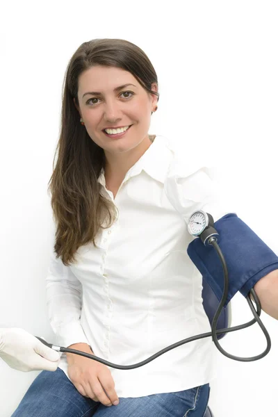 Junge Frau mit einem Blutdruckmessgerät — Stockfoto