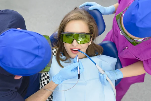 Frau bekommt Bleaching-Laser beim Zahnarzt — Stockfoto
