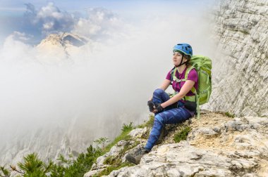 Dağcı kadın Triglav, Slovenya 'nın yüksekliğinden inanılmaz bir manzaranın keyfini çıkarıyor, yaz günü.