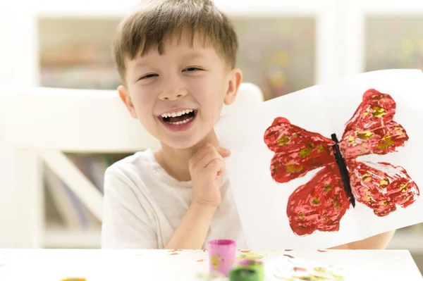 誇り高い子供は幼稚園で彼の蝶のペイントクラフトを示す — ストック写真