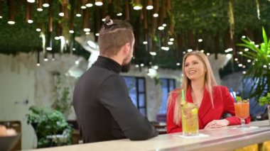 Genç çift bistro barda buluşmaktan zevk alıyor. Barmen kokteyl hazırlıyor..