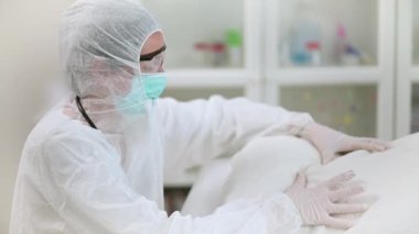 Bir hastayı kaybettikten sonra hastane odasında boş bir yatakta yastığı sıktığı için pişmanlık duyan doktor kadın.