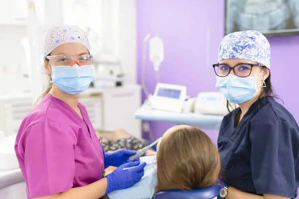 Junge Zahnärztin Und Assistentin Bei Der Behandlung Eines Schnullers Der lizenzfreie Stockfotos