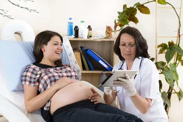 Zwangere vrouw controleren resultaten op tablet pc — Stockfoto