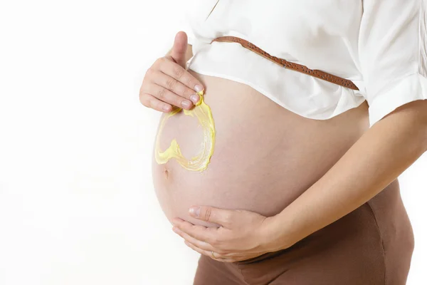 Mujer embarazada aplicando crema hidratante —  Fotos de Stock