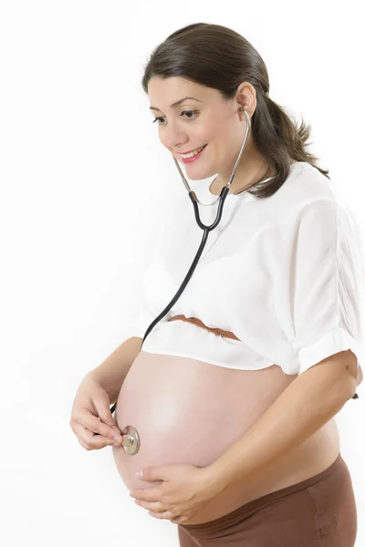 Kobieta w ciąży słuchając jej dziecko — Zdjęcie stockowe